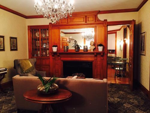 Cozy living room with wooden accents, a fireplace, chandelier, and a view into a dining area.