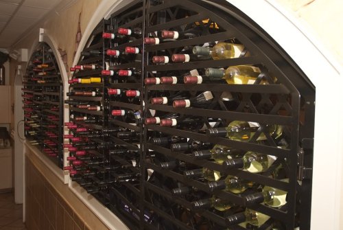 A wine rack displaying various bottles of red and white wine in a stylish, organized arrangement.