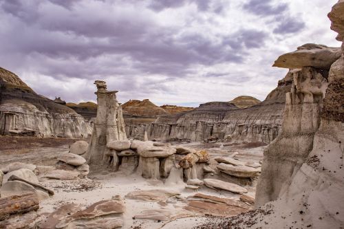 A rugged landscape featuring unique rock formations and cloudy skies, showcasing earthy tones and textures.