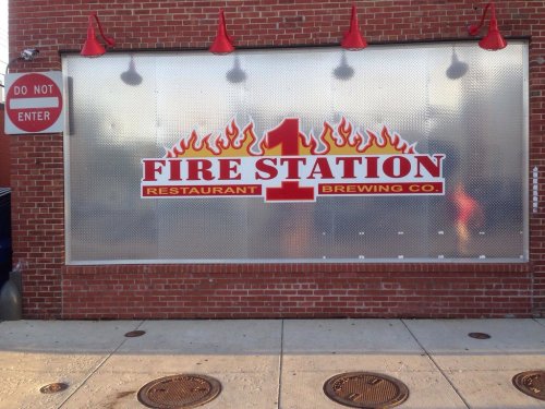 Sign for "Fire Station 1 Restaurant & Brewing Co." on a brick wall, with a "Do Not Enter" sign nearby.
