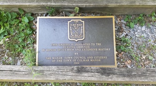 Plaque dedicating a gazebo to the dueling grounds, honoring Colmar Manor's history, established in 2004.