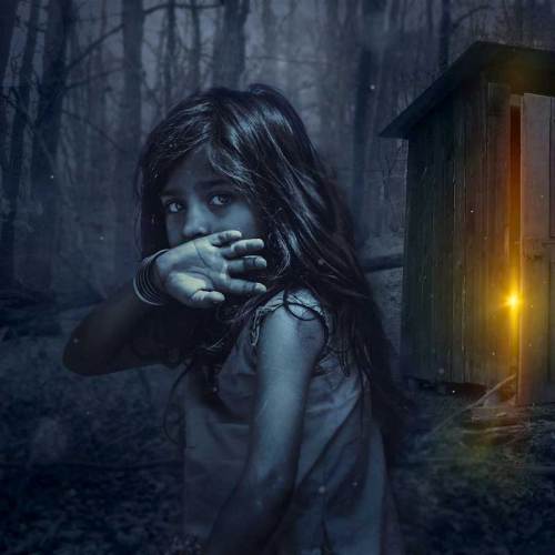 A girl with long hair stands in a dark forest, covering her face, with a glowing shed in the background.