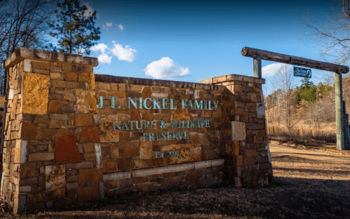 Stone entrance sign for J.T. Nickel Family Nature & Wildlife Preserve, established 2009, surrounded by trees.