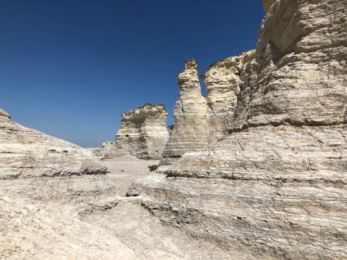 A rocky landscape featuring tall, white cliffs under a clear blue sky.