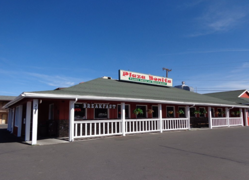 Exterior of Plaza Bonita, a family Mexican restaurant, featuring a sign and a welcoming porch under a clear blue sky.