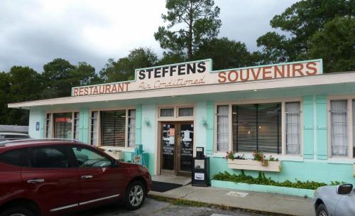 A turquoise building with a sign reading "Steffens Restaurant" and "Souvenirs," featuring a welcoming entrance.