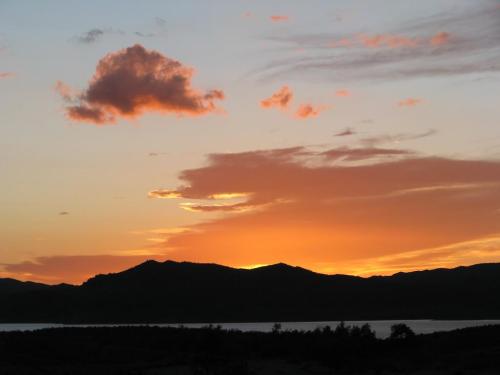 A serene sunset over mountains, with soft clouds and a gradient of warm colors in the sky.