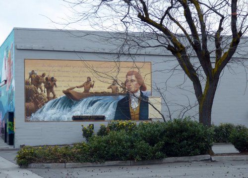 A mural depicting a historical scene with a man in period clothing, a river, and figures in a boat, surrounded by trees.