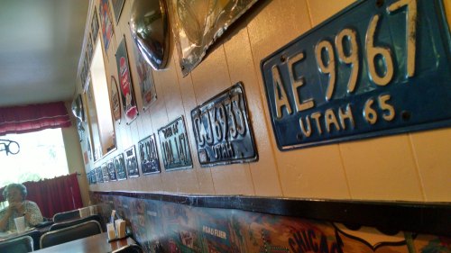 A cozy diner interior featuring vintage Utah license plates displayed on the walls.