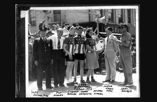 Black and white photo of a 1940 celebration with athletes, officials, and a mayor, all wearing patriotic outfits.