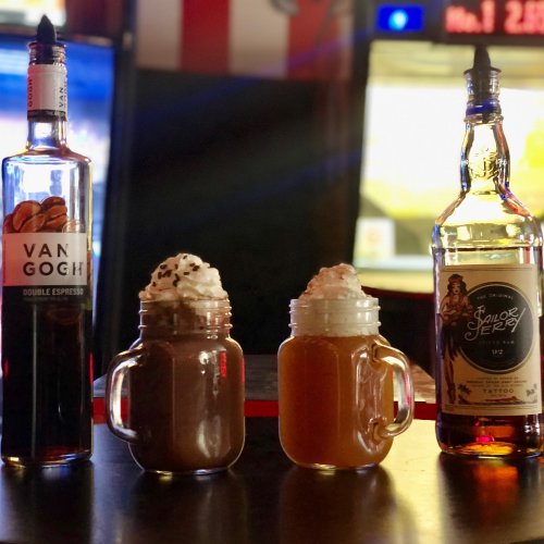 Three jars with whipped cream and drinks, flanked by bottles of Van Gogh Double Espresso and Schlong's Jerky whiskey.