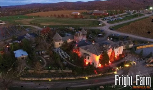 Aerial view of Fright Farm in Smithfield, PA, featuring a spooky mansion and surrounding fields at dusk.