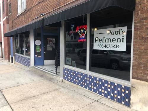 Exterior of Paul's Pel'meni restaurant, featuring a sign with the name and phone number, and colorful tiled windows.