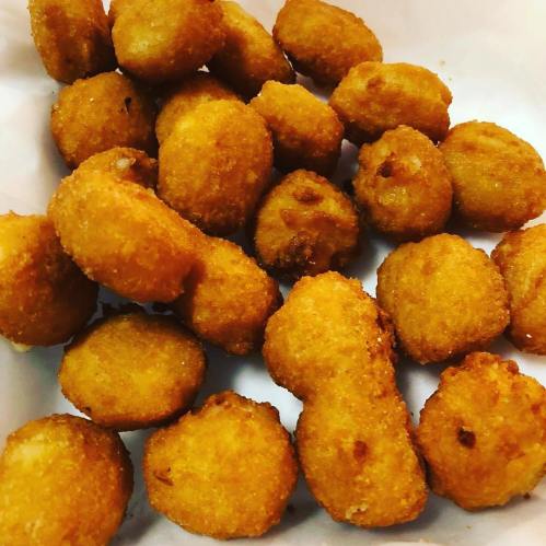 A pile of golden-brown, crispy fried snacks on a white surface.