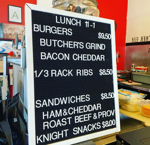 Menu board displaying lunch items and prices: burgers, ribs, sandwiches, and snacks.