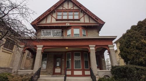 Historic building with a decorative facade, featuring a sign that reads "Chautauqua Museum" and a welcoming entrance.
