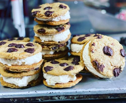 A stack of chocolate chip cookie ice cream sandwiches on a metal tray, showcasing their delicious layers.