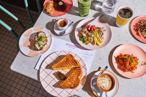 A vibrant table spread with various dishes, coffee, and menus at Moonshot Coffee Bar.
