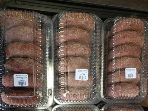 Three containers of apple cider donuts, each labeled with a price of $4.99.