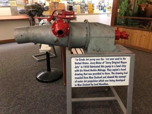 A vintage Crude Jet pump displayed with a sign explaining its history and significance in water jet propulsion development.
