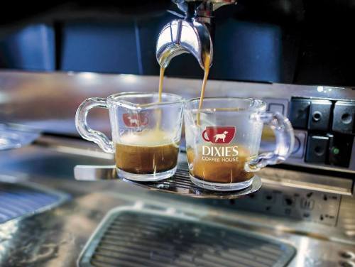 Two glass espresso cups are being filled with coffee from an espresso machine at Dixie's Coffee House.