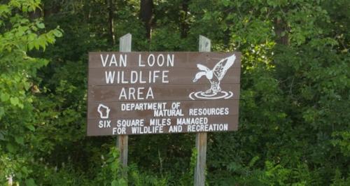 Sign for Van Loon Wildlife Area, managed for wildlife and recreation, surrounded by greenery.