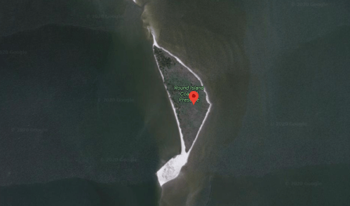 Aerial view of Round Island, featuring a narrow landmass surrounded by water and sandy shores.
