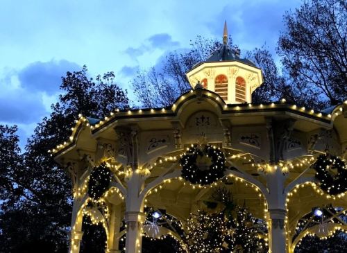 A beautifully lit gazebo adorned with Christmas lights against a twilight sky.