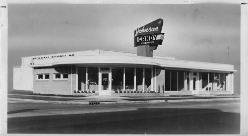 Black and white image of Johnson Candy Company storefront with a retro sign and large windows.