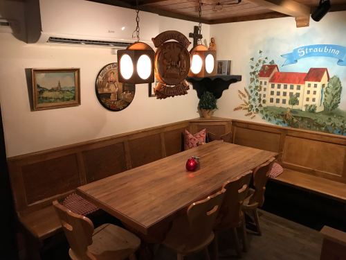 Cozy dining area with a wooden table, benches, and decorative wall art in a warm, inviting atmosphere.