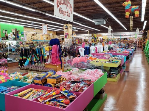 A colorful store aisle filled with various merchandise, including toys, clothing, and party supplies.