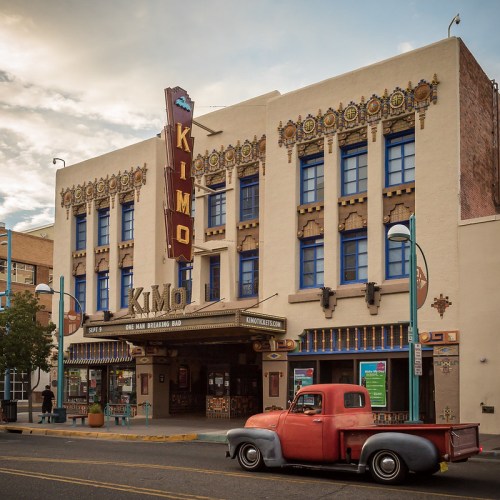 Historic Kimo Theatre building with colorful art deco design, featuring a vintage red pickup truck parked in front.