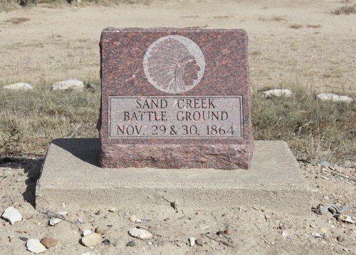 Granite monument marking the Sand Creek Battle Ground, dated November 29 & 30, 1864, in a grassy area.