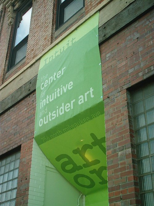 Green banner on a brick building reads "Intuit: the center for intuitive and outsider art" with an address below.