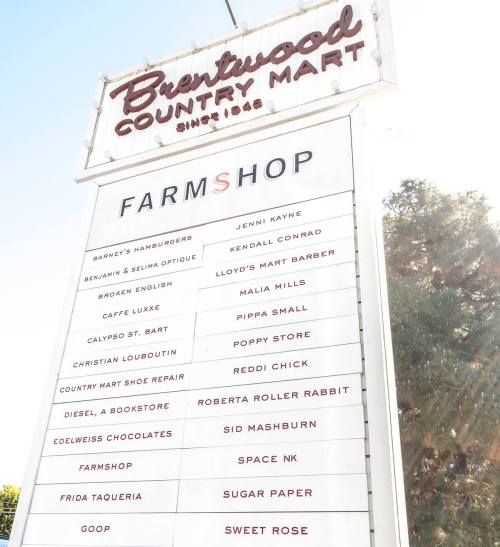 Sign for Brentwood Country Mart listing various shops and eateries, including Barney's Hamburgers and Jenni Kayne.