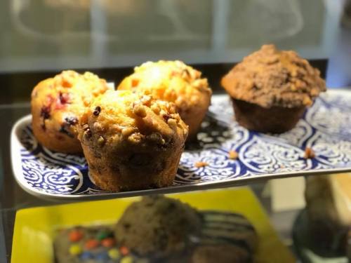 A plate of assorted muffins, including cranberry and chocolate, displayed on a decorative blue and white dish.