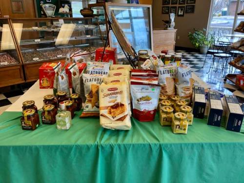 A display of various food products, including flatbreads, sauces, and snacks, arranged on a green tablecloth.