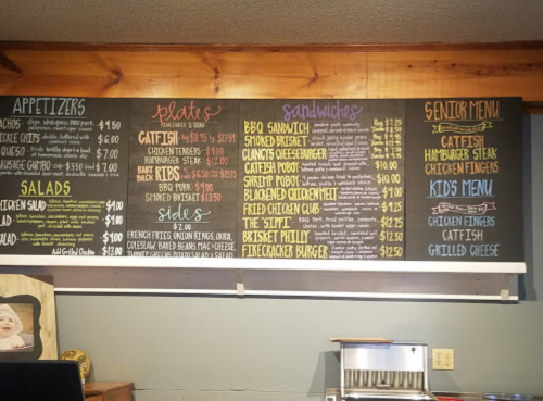 Chalkboard menu featuring appetizers, plates, sandwiches, and kids' options with prices listed.