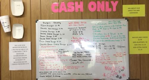 Menu board displaying food items and prices, including burgers, chicken, and sides, with a "Cash Only" notice.