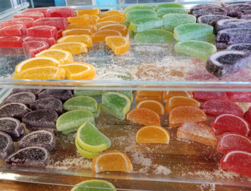Colorful gummy candies arranged in layers, featuring various fruit shapes in red, green, orange, yellow, and purple.