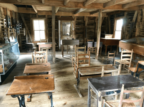 A rustic classroom with wooden desks and chairs, featuring a warm, inviting atmosphere and vintage decor.