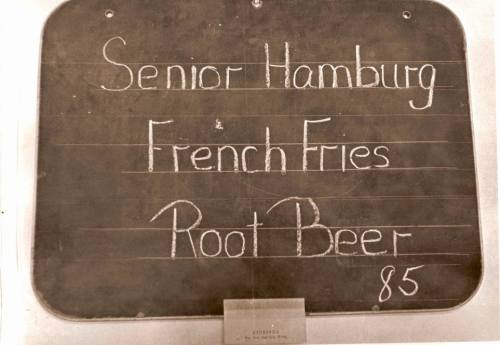 Menu board listing "Senior Hamburg," "French Fries," and "Root Beer" with a price of 85 cents.