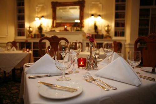Elegant dining setup with white tablecloths, glassware, and candlelight in a cozy restaurant setting.