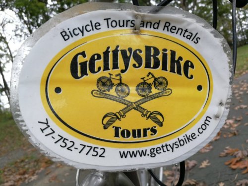 Logo for GettysBike Tours featuring bicycles and crossed paddles, with contact info and website details.