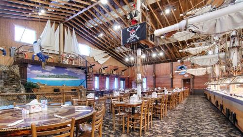 Interior of a pirate-themed restaurant with wooden tables, ship decor, and a mural of an island.