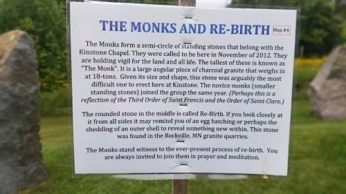 A sign describing a semi-circle of standing stones called "The Monks," reflecting on rebirth and connection to nature.