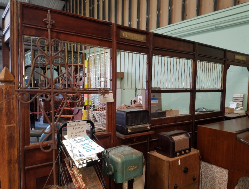 Vintage wooden display cases and antique radios in a retro shop setting.