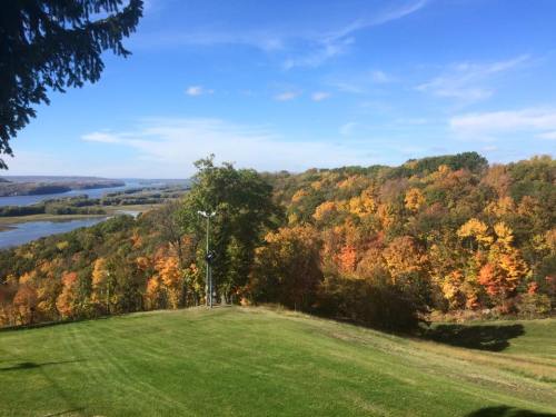 A scenic view of a river surrounded by vibrant autumn foliage and a clear blue sky.
