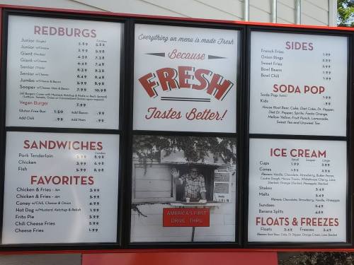 Menu board featuring food items like sandwiches, sides, ice cream, and drinks, highlighting "Fresh Tastes Better."