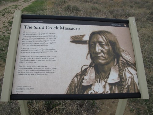 Sign about the Sand Creek Massacre, detailing the event and its impact on Native Americans, with a historical image.